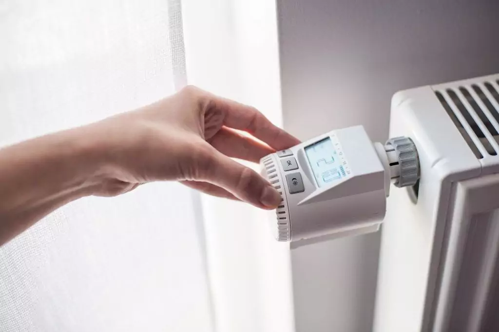 Heizungsoptimierung mit modernem, digitalen Thermostat am Heizkörper