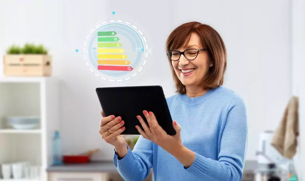 Symbolbild zur Energieeffizienz eines Hauses: eine Frau blickt lächelnd auf ein Tablet